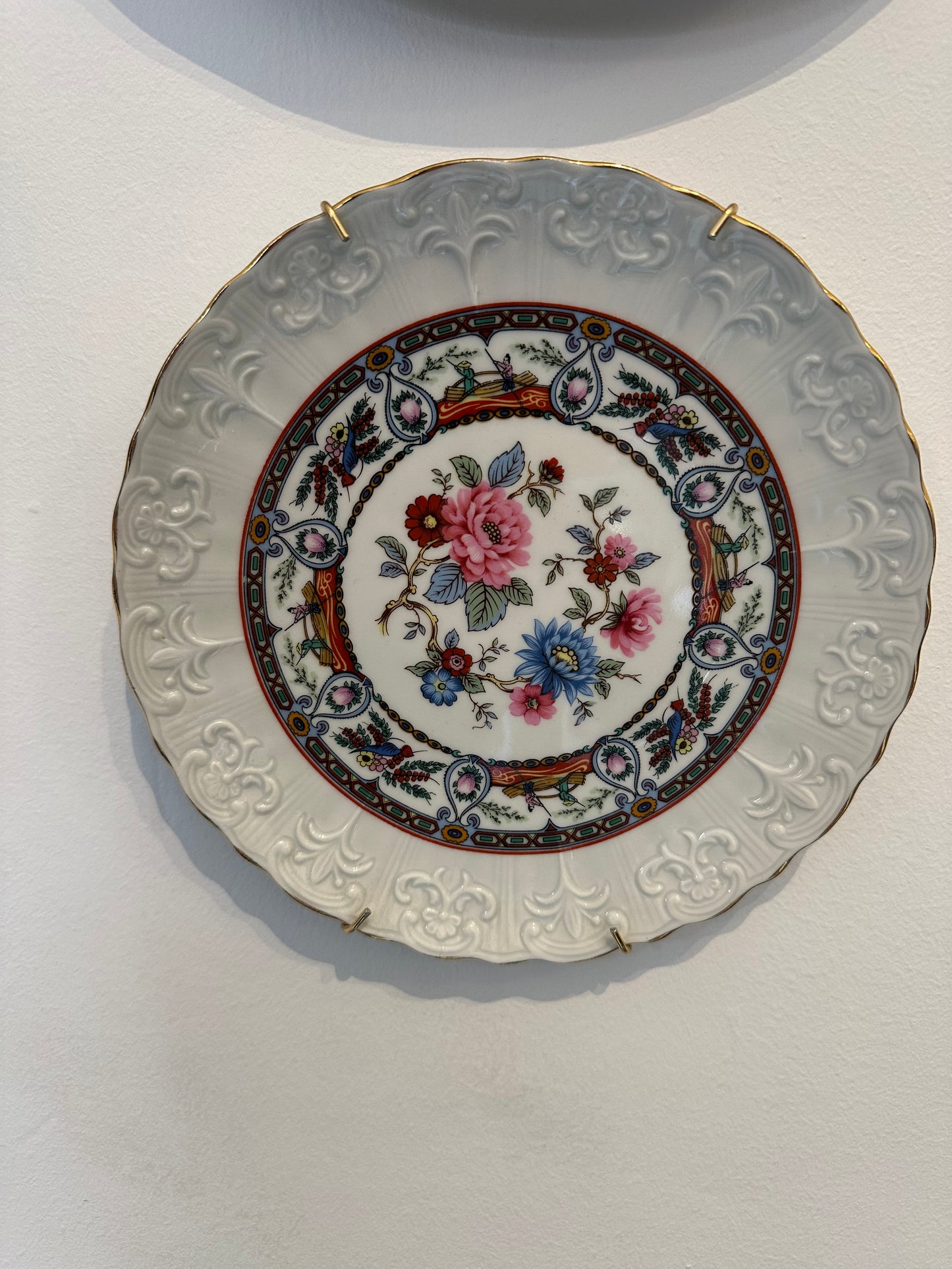 Plato decorativo de porcelana con relieves y borde dorado